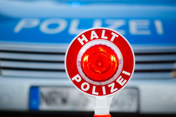 Polizeikelle vor Polizeiauto