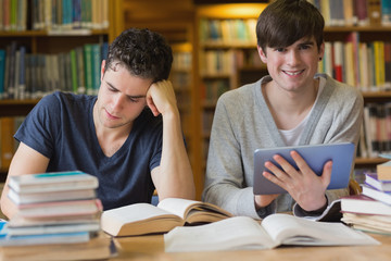 Young man with tablet pc in the library