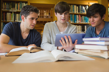 Men sitting at the library looking at tablet pc