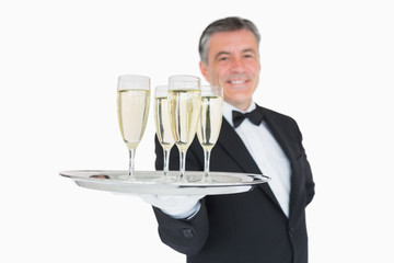 Waiter serving tray full of glasses with champagne