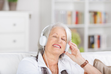 moderne seniorin hört musik mit kopfhörern