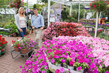 Couple pushing trolley full of flowers