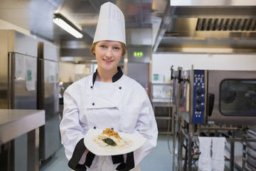Cheerful chef showing her plate