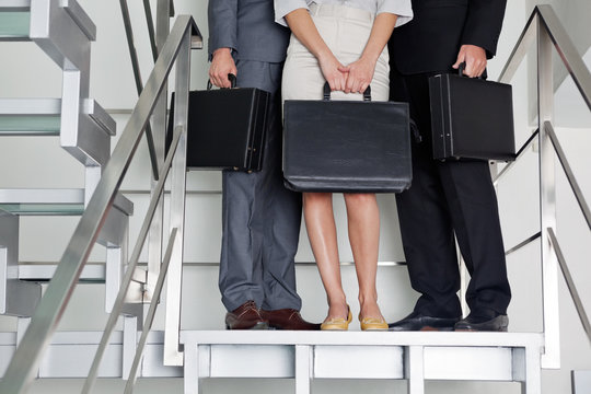 Businesspeople With Briefcases Standing On Steps