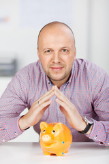 lächelnder mann mit sparschwein