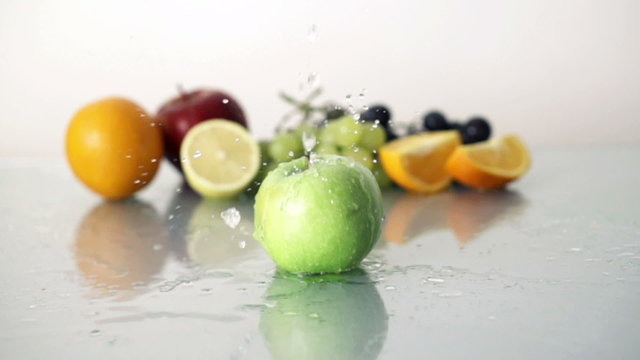 Pouring water on tasty green apple, slow motion shot at 480fps