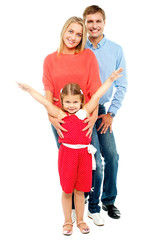 Cheerful family of three posing indoors