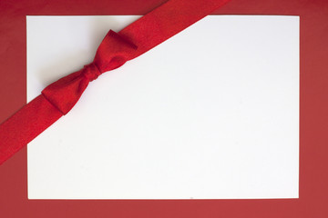 Christmas sheet of paper and red ribbon gift background