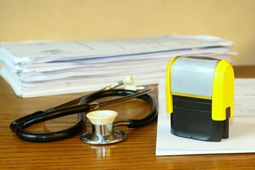Stamp and a stethoscope on a medical table - obrazy, fototapety, plakaty