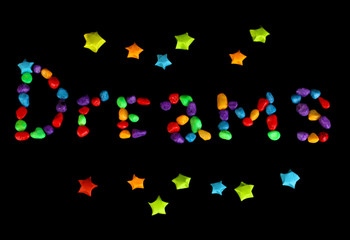 The word Dreams with colorful paper stars with dreams isolated