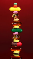 Capsules and pills on red background
