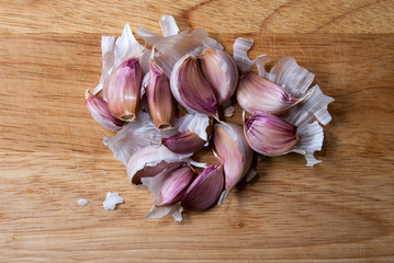 Garlic cloves on wooden chopping board