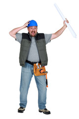 Naklejka premium hilarious foreman standing holding blueprints