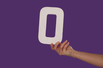 Female hand holding up the number 0 from the right