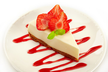 cheesecake with strawberries on white plate