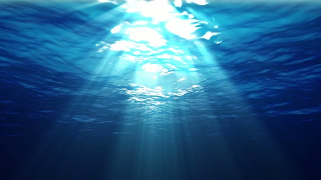 Underwater sunrays shine through the water's surface. Looping.