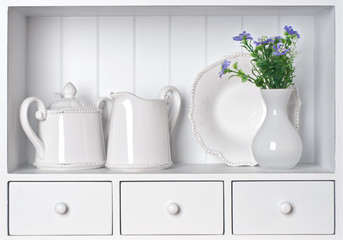 White shelf with vintage porcelain tableware
