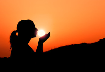 Silhouette of a girl kissing the sun