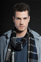 Obraz premium Handsome man dark winter fashion. Studio shot. Wearing scarf.