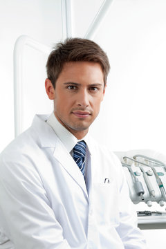 Serious Male Dentist In Clinic