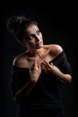 Young attractive fashion model posing on dark background
