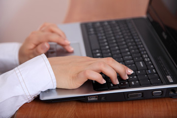Piękne dłonie na klawiaturze laptopa.