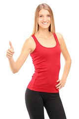 Young smiling athletic female giving a thumb up