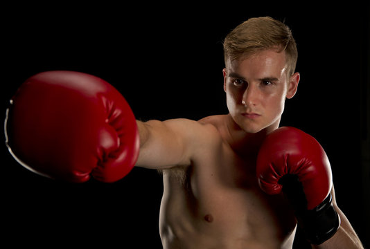 Isolated On A Black Background Boxer Extends His Right Jab