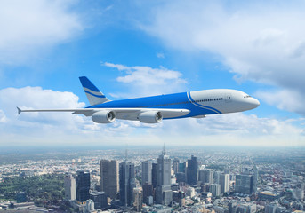 Fototapeta na wymiar Biały samolot pasażerski latający nad miastem