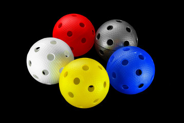 Five floorball balls isolated on a black background