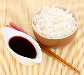 Bowl of rice and chopsticks on bamboo mat