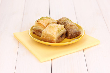 Sweet baklava on plate on wooden background