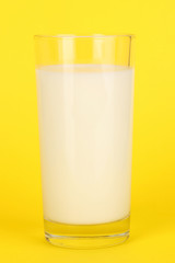 Glass of fresh new milk on yellow background