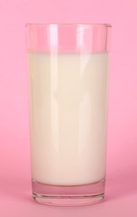 Glass of fresh new milk on pink background