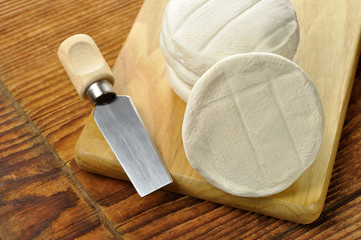 Italian tomino cheese on a wooden chopping board