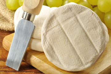 Italian tomino cheese on a wooden chopping board