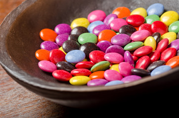 A bowl of candy coated chocolates.