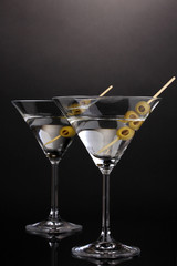 Martini glasses and olives on grey background