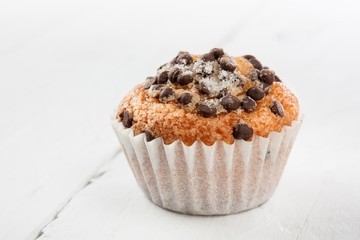 Chocolate chip muffin on white wood