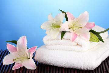 Fototapeta na wymiar stos ręczników różowy lilia na niebieskim tle