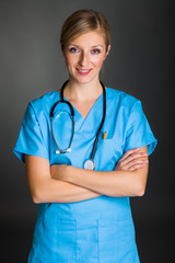 Woman in medical doctor suit on gray