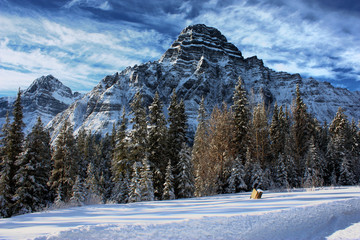 Rocky mountain peaks under clouds in a blue sky