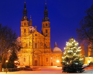 Fototapeta na wymiar Fulda Cathedral śniegiem i oświetlone choinki w nocy