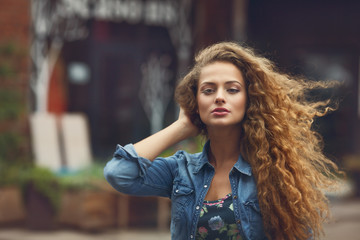 Beautiful young Caucasian girl with curly hair outdoors