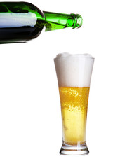 Beer pouring from green bottle into glass isolated on white