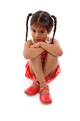 enfant triste assise sur fond blanc