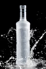 Keuken spatwand met foto iced bottle of vodka splash on a black background © REDSTARSTUDIO