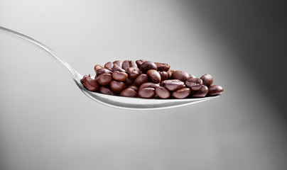 a coffe beans on a spoon