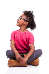 Cute young African American girl seated on the floor