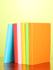 Stack of multicolor books   on green background
